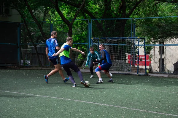 Rosja, Chabarowsk - 11 czerwca 2019: street domestic playing soccer. Młodzi grają w piłkę na zielonej trawie. — Zdjęcie stockowe