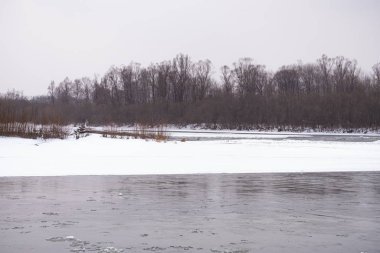 Kışın Rus Dağı nehri. Kıyıda kar var. Buzlu suyun hızlı akışı.