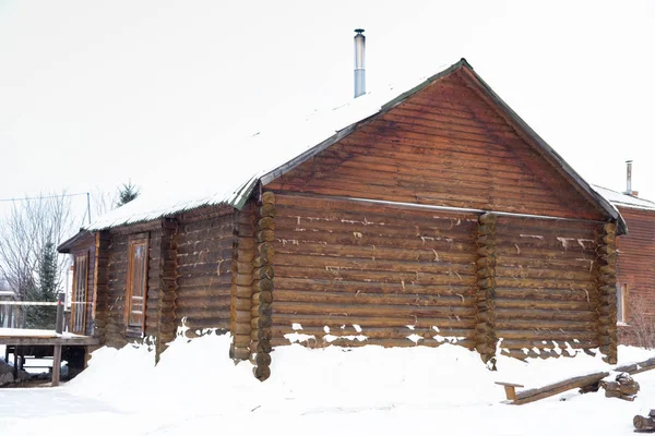 Ruská dřevěná lázeň v zimě. Padlý bílý sníh leží na zemi. — Stock fotografie