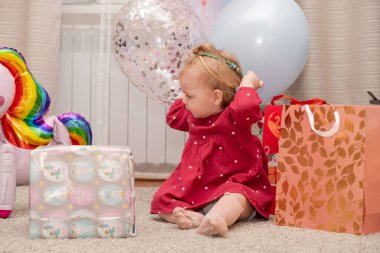 Khabarovsk, Russia - Dec 31, 2019: Little girl with birthday gifts and balloons.