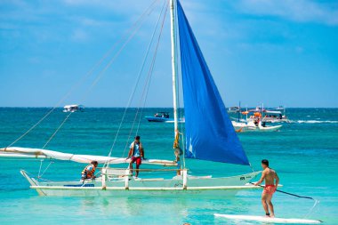 Boracay, Filipinler - 20 Ocak 2020: Gündüz vakti Boracay adasının boş beyaz plajı. Koronavirüs yüzünden Çinli turist yok. Denizdeki tekneler turist taşır..