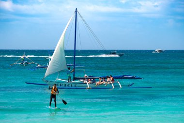 Boracay, Filipinler - 20 Ocak 2020: Gündüz vakti Boracay adasının boş beyaz plajı. Koronavirüs yüzünden Çinli turist yok. Denizdeki tekneler turist taşır..
