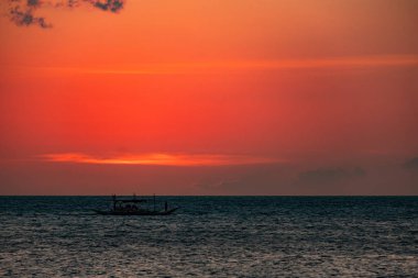 Boracay, Filipinler - 21 Ocak 2020: Barda duran şişelerin arka planında gün batımı. Güneş, şişelerin parlak camından geçer. Ekran koruyucu için arkaplan resmi.