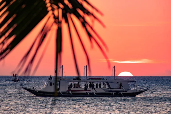 Boracay, Philippinen - 21. Januar 2020: Sonnenuntergang auf dem Hintergrund von Flaschen, die auf der Theke stehen. Die Sonne wandert durch das helle Glas der Flaschen. Hintergrundbild für den Bildschirmschoner. — Stockfoto