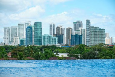 Manila, Filipinler - Şubat 02, 2020. Manila şehrinin beş yıldızlı lüks Discovery Primea otelinin havuzundan görünüşü. Güneşli bir hava. Arka planda gökdelenler.