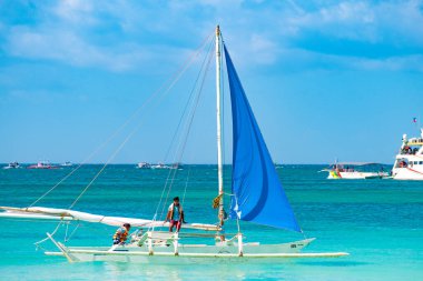 Boracay, Filipinler - 20 Ocak 2020: Gündüz vakti Boracay adasının boş beyaz plajı. Koronavirüs yüzünden Çinli turist yok. Denizdeki tekneler turist taşır..