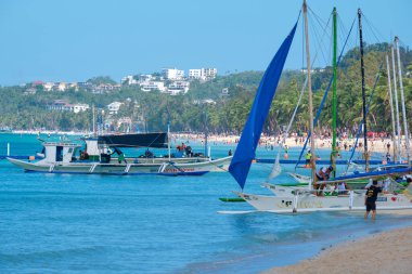 Boracay adasının beyaz plajı. Turistler plaj boyunca yürür ve denizde yüzerler. Coronavirüs salgınından birkaç gün önce..