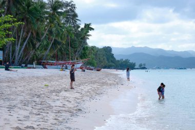Boracay adasının beyaz plajı. Turistler plaj boyunca yürür ve denizde yüzerler. Coronavirüs salgınından birkaç gün önce.