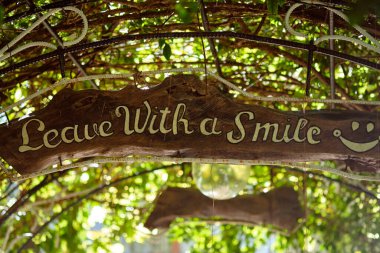 Üzerinde yazı olan tahta tabela Gülümseyerek ayrıl