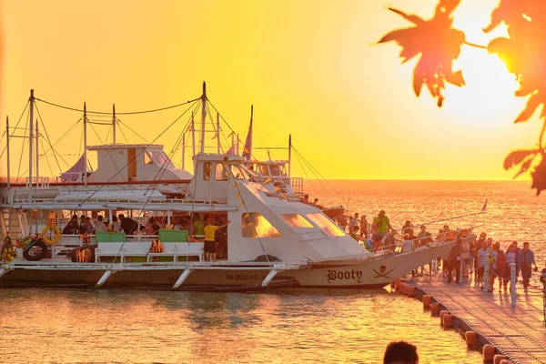 Boracay, Filipinas - 23 de enero de 2020: Puesta de sol en el fondo de las botellas de pie en la barra. El sol pasa a través del cristal brillante de las botellas. Imagen de fondo para el salvapantallas . — Foto de Stock