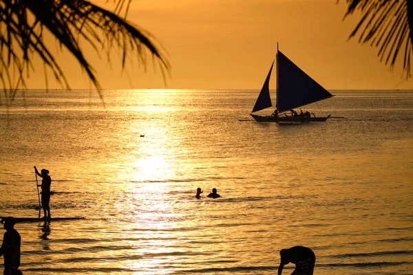 Boracay, Filipinas - 26 de enero de 2020: Puesta de sol en el fondo de las botellas de pie en la barra. El sol pasa a través del cristal brillante de las botellas. Imagen de fondo para el salvapantallas. — Foto de Stock