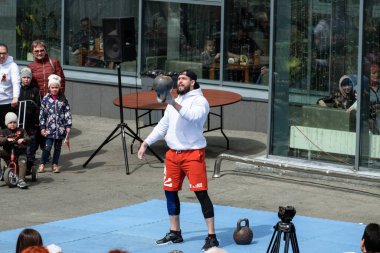 Khabarocsk, Rusya - 09 Mayıs 2019: Büyük Vatanseverlik Savaşı 'ndaki Zafer Günü onuruna verilen konser. Beyaz elbiseli bir atlet ağır topları fırlatır.