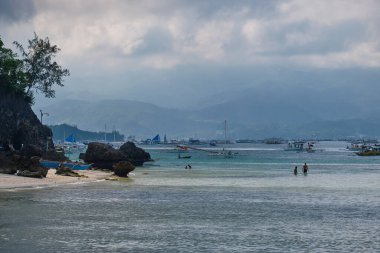 Boracay adasının beyaz plajı. Turistler plaj boyunca yürür ve denizde yüzerler. Coronavirüs salgınından birkaç gün önce.
