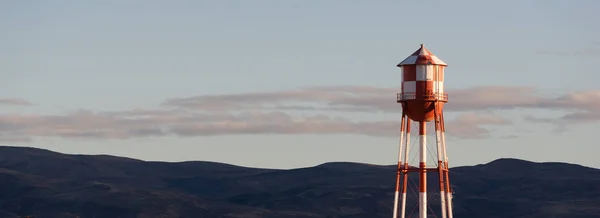 Kırmızı beyaz kareli su kulesi dağ arka plan — Stok fotoğraf