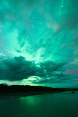 Lake Reflects Aurora Borealis Emerging Through Clouds Remote Alaska clipart