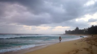 Sörfçü yürüyüş okyanus kıyısındaki Beach bulutlu fırtınalı gün Shore Surf