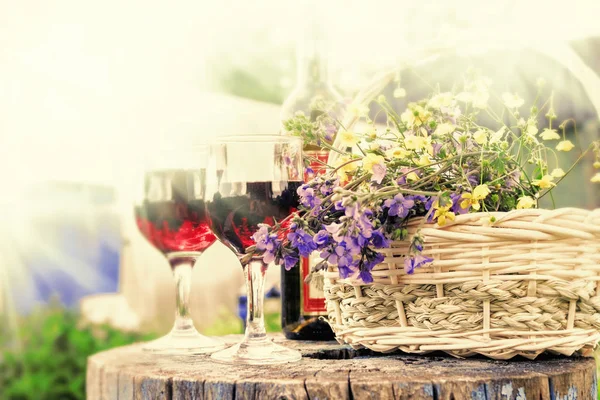 Glasses with red wine and flowers — Stock Photo, Image