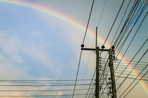 Electric pole with Rainbow and blue sky — Stock Photo, Image