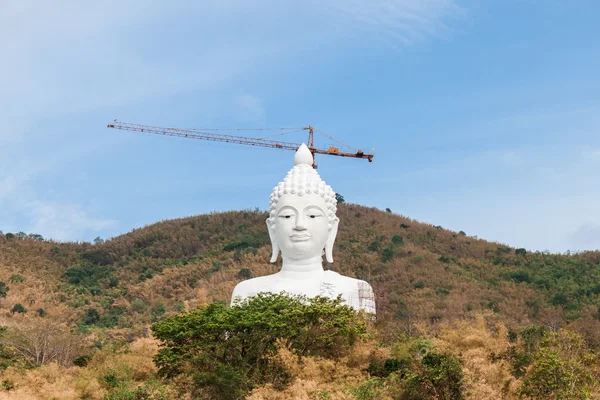 Vit buddha på berget med kran och byggnadsställningar — Stockfoto