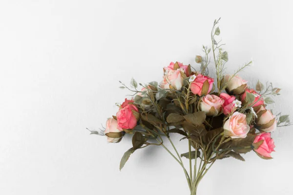 Hermosas rosas ramo (flores artificiales) en la pared blanca —  Fotos de Stock