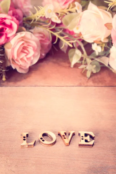 Palabra Amor con flor de rosa en mesa de madera — Foto de Stock