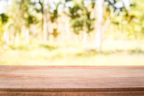 Tablo ve güneş ışığı ile bulanık ağaçlar arka plan, boş ahşap