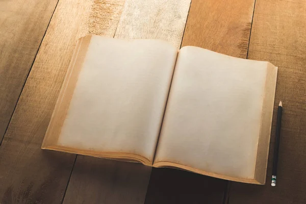 Παλιά κενό βιβλίο άνοιγμα με μολύβι πάνω στο ξύλινο τραπέζι — Φωτογραφία Αρχείου