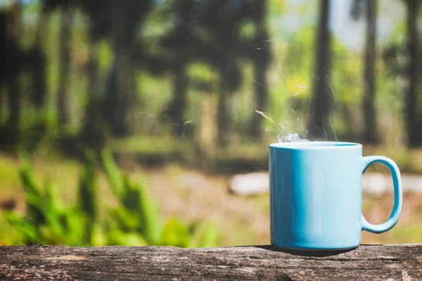 Φλιτζάνι καφέ ή τσάι στην σανίδα ξύλου με φόντο πράσινο της φύσης — Φωτογραφία Αρχείου