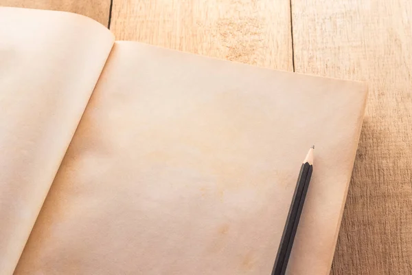 Oude boek met blanke pagina open met potlood op de houten tafel — Stockfoto