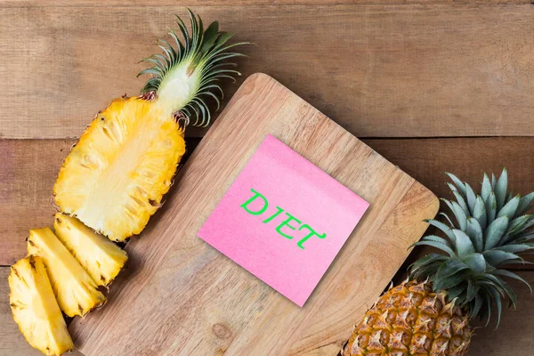 Pineapple slice on wood cut board with diet text on paper note, healthy concept — Stock Photo, Image