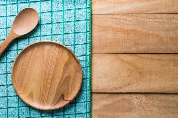 Placa de madera vacía y cuchara sobre mesa de madera con mantel —  Fotos de Stock