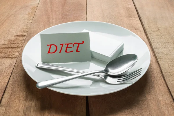 Conceito de dieta, texto de dieta no cartão de visita no prato branco e colher com garfo — Fotografia de Stock