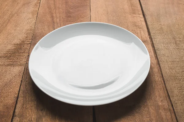 Plato blanco vacío sobre mesa de madera —  Fotos de Stock