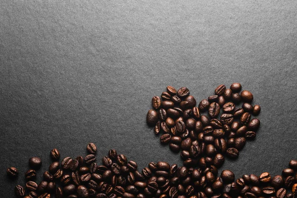 Concept de café Love, Coeur de grains de café torréfiés sur fond noir . — Photo