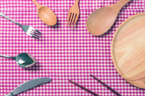 Kitchen tools background.spoon,fork,knife,plate and chopsticks on red Tablecloth.top view. — Stock Photo, Image