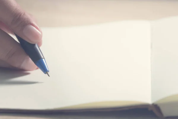 Primo piano mano studente con penna scrittura su notebook . — Foto Stock