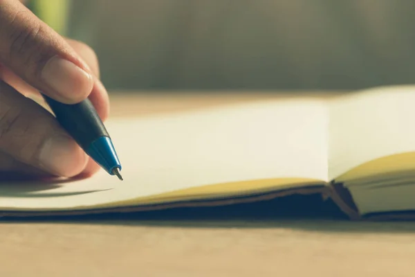 Detailní záběr studentů ruku s perem, psaní na notebooku. — Stock fotografie