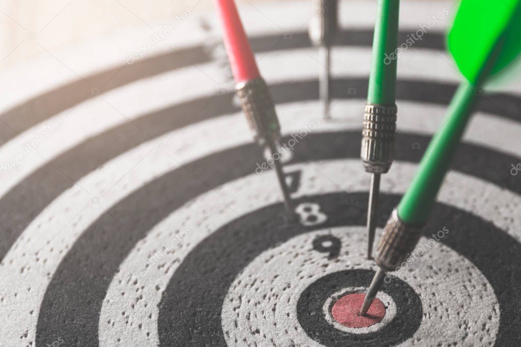 dart arrow hitting in the target center of dartboard,abstract of success