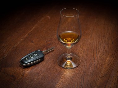 bir araba anahtarı bir masada içki cam