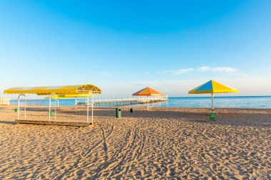 Plaj şemsiyeleri ile denizde. Pier