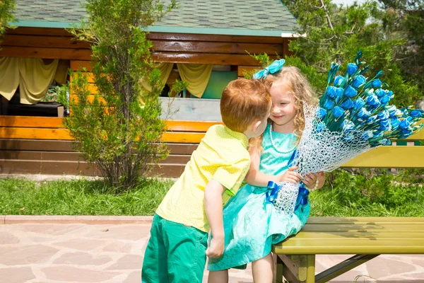 Pojken får en blomma flicka barn på födelsedagen. Celebration koncept och barndom, kärlek — Stockfoto