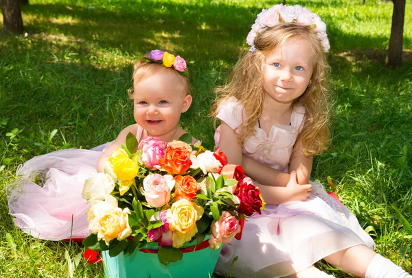 İki kız kardeş. Sevimli küçük çocuk kızlarla buket çiçek Doğum günün kutlu olsun. Yaz yeşil doğa arka plan. — Stok fotoğraf