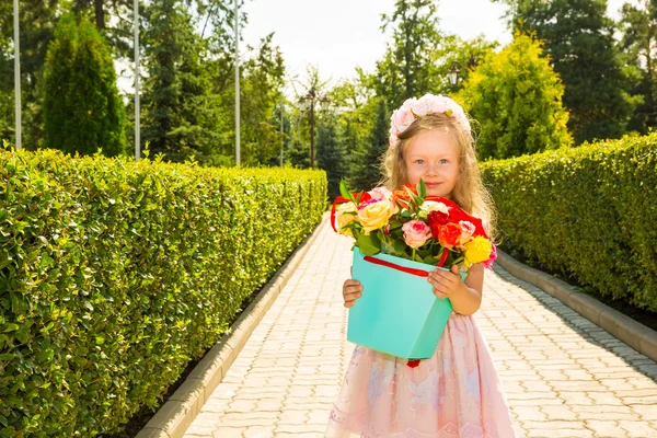 Adorabile bambina con mazzo di fiori per buon compleanno. Estate sfondo verde natura. Usalo per il bambino, genitorialità o concetto di amore — Foto Stock