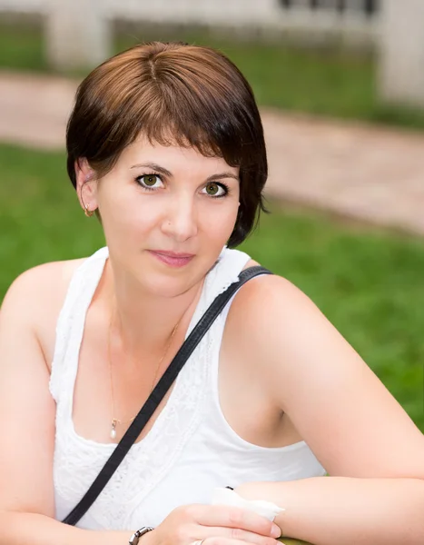 Portrait de la jeune belle femme souriante avec des fleurs à l'extérieur — Photo