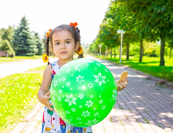 Adorable little child girl with balloons on summer nature background. — Stock Photo, Image
