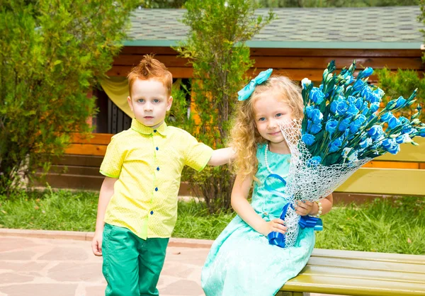 Το αγόρι δίνει ένα λουλούδι σε ένα παιδί κορίτσι για χαρούμενα γενέθλια. Γιορτή έννοια και παιδικής ηλικίας, αγάπη — Φωτογραφία Αρχείου