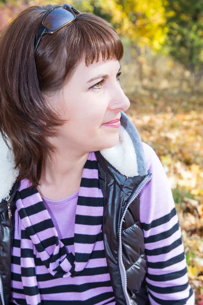 Vallen. Portret van mooie jonge vrouw in herfst park met esdoorn bladeren — Stockfoto