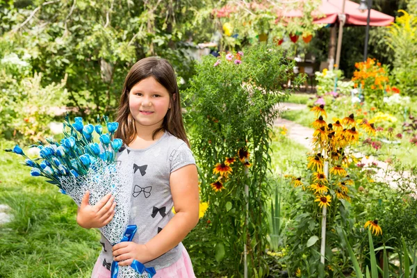 Adorable petite fille avec bouquet de fleurs le jour de joyeux anniversaire. Été vert nature fond. Utilisez-le pour bébé, parental ou concept d'amour — Photo