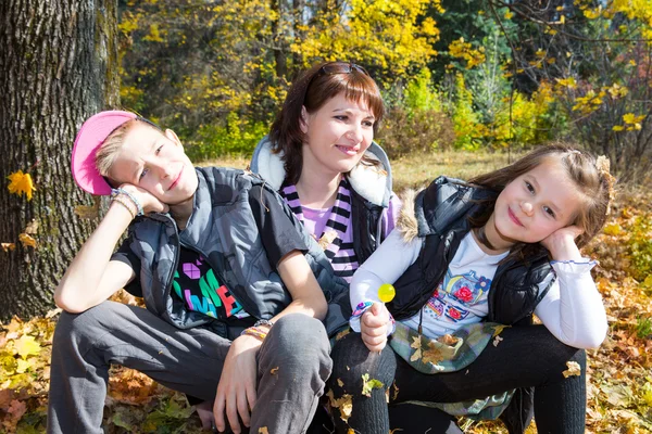 Porträt der jungen schönen lächelnden Frau mit langen Haaren und Outdoor. glückliche Mutter und Kinder, die sich in der Natur umarmen — Stockfoto