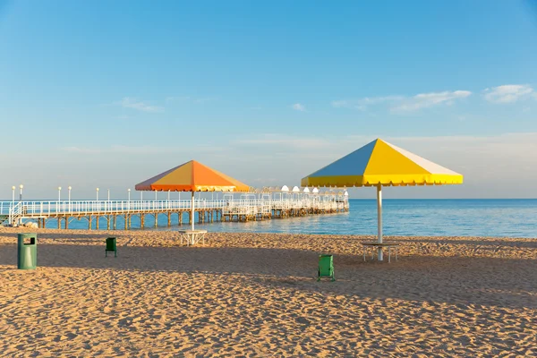 Pláž u moře s deštníky. Pier — Stock fotografie